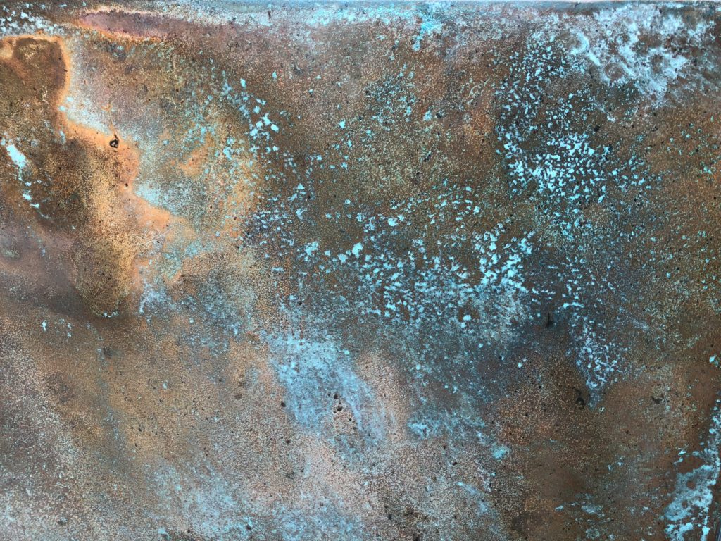 A close-up of patinated copper panels reveals a textured pattern of greenish-blue patina contrasted with the brownish tones of the corroded metal, creating a rustic and aged appearance.