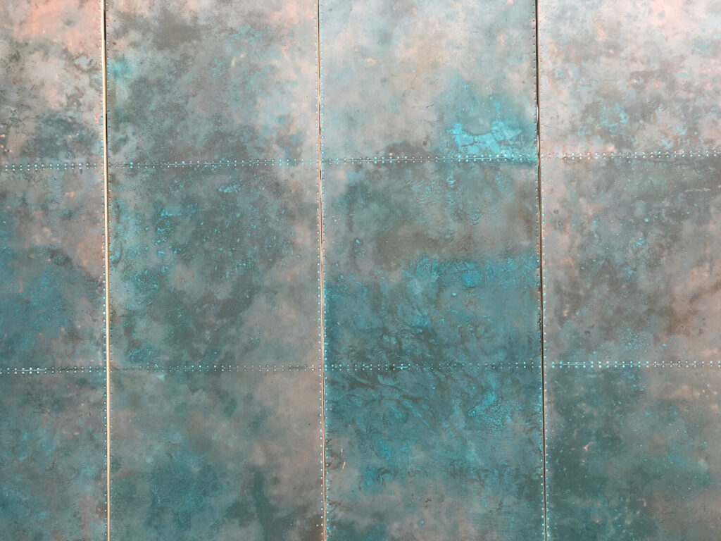 Green verdigris on bespoke copper wall panels