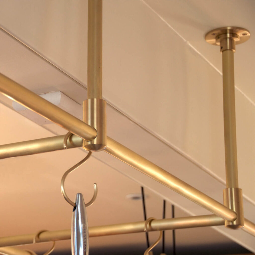 Brushed brass pot rack hanging from the ceiling